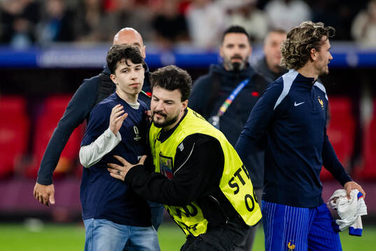 A pitch invader next to Antoine Griezmann of France