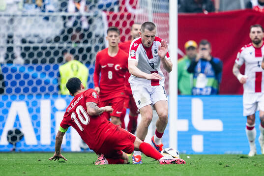 Hakan Calhanoglu of Türkiye and Giorgi Chakvetadze of