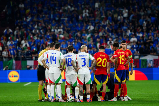 Players of Italy and of Spain protect Rodrigo Hernandez in