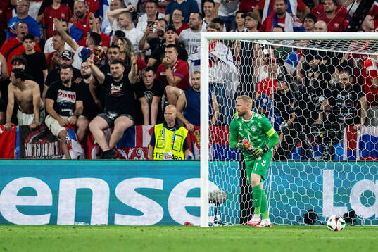 Goalkeeper Kasper Schmeichel of Denmark picking up plastic