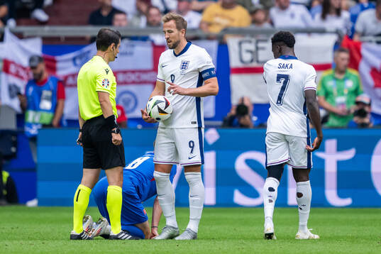 Referee Umut Meler and Harry Kane of England