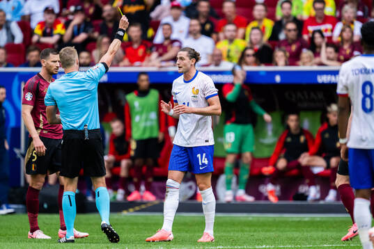 Referee Glenn Nyberg gives Adrien Rabiot of France a warning
