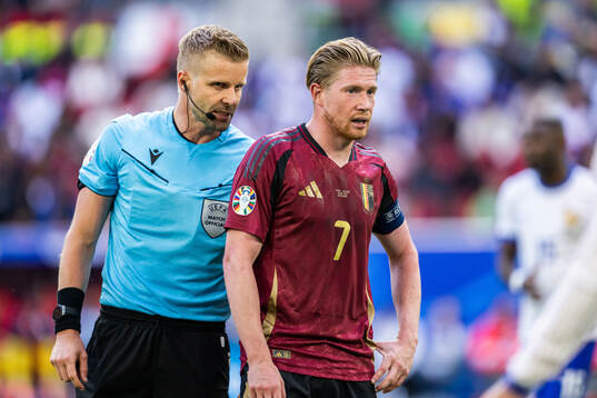 Referee Glenn Nyberg and Kevin De Bruyne of Belgium