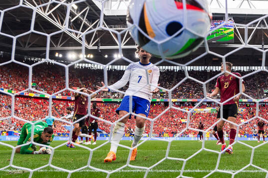 Antoine Griezmann of France celebrates and Timothy Castagne