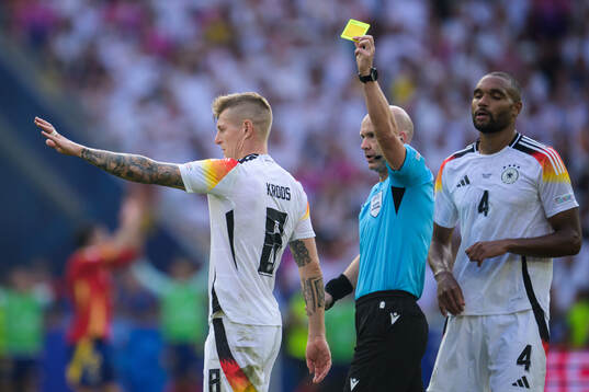 Toni Kroos of Germany receives a yellow card from referee