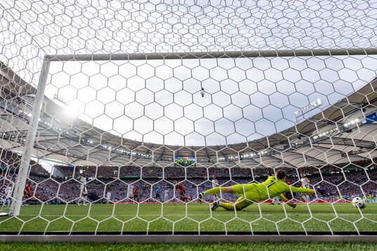 Daniel Olmo of Spain scores 1-1 behind goalkeeper Manuel