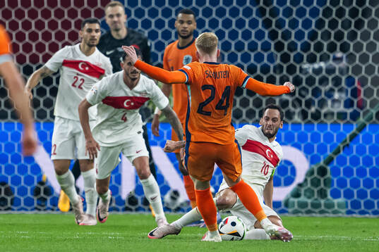 Jerdy Schouten of Netherlands and Hakan Calhanoglu of Turkey