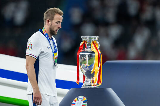 Harry Kane of England looks dejected as he walks past the