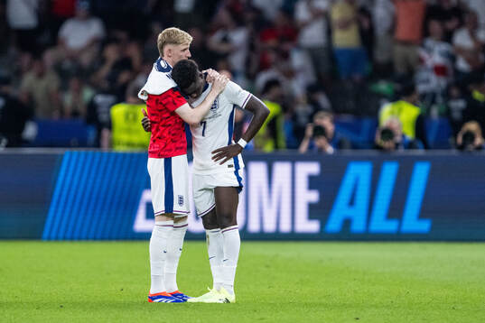Anthony Gordon and Bukayo Saka of England look dejected