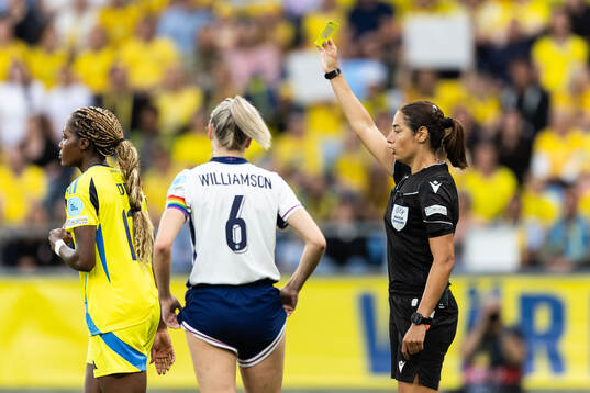 Evelyn Ijeh of Sweden receives a yellow card from Referee