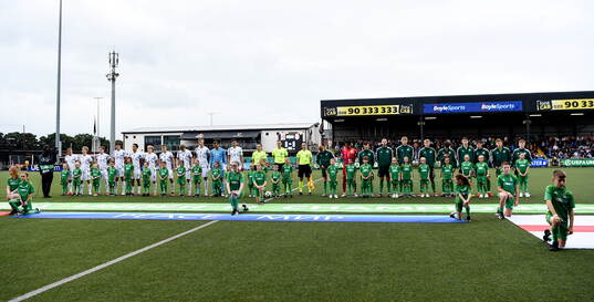Both teams stand for the playing of the national anthems