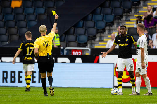 Domare Adam Ladebäck visar gulkort till AIKs Mouhamed