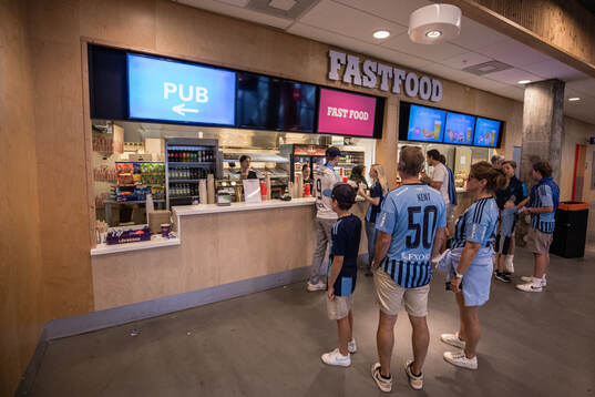 Glest med besökare vid en kiosk på Tele2 Arena