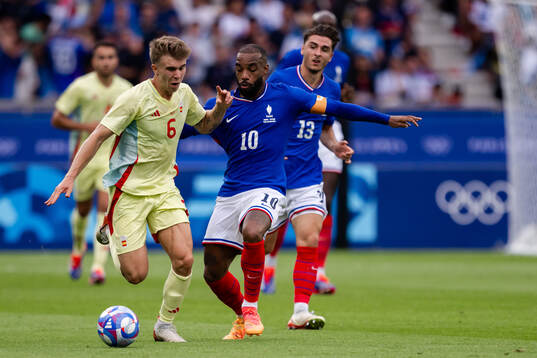 Pablo Barrios of Spain and Alexandre Lacazette of France in