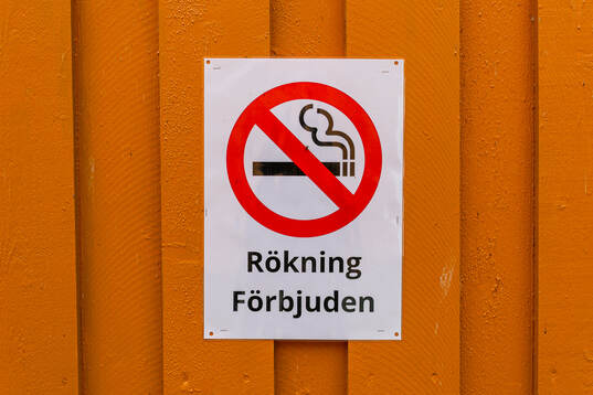 En skylt med ”rökning förbjuden” på en vägg på