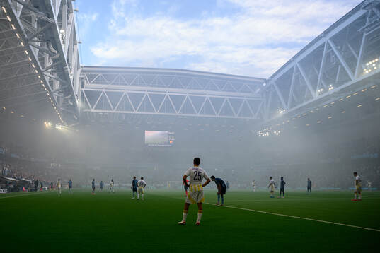 The referee pauses the game due to smoke in the arena