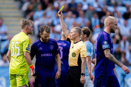 Djurgårdens målvakt Jacob Rinne får en varning av Domare