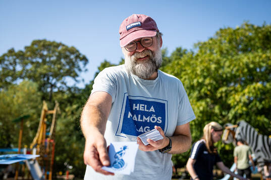 En representant från Supporterhuset säljer klistermärken