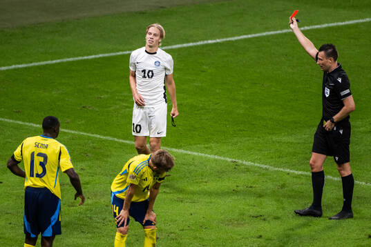 Kevor Palumets of Estonia receives a red card from  referee