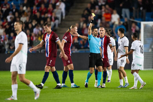 Referee Vladan Todorovic gives a yellow card to Phillipp