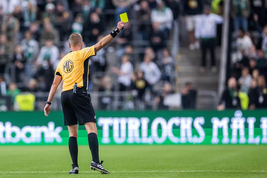 Domare Richard Sundell visar det gula kortet