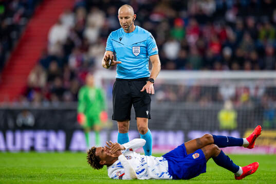 Referee Tamás Bognár and Antonio Nusa of Norway