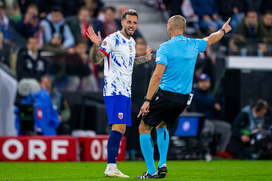 Aron Dønnum of Norway and referee Tamás Bognár