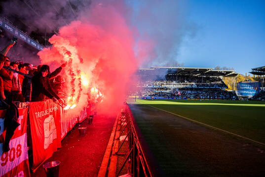 Spectators in the stands with flares