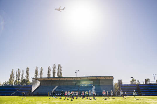An airplane passes over players of the Swedish women's
