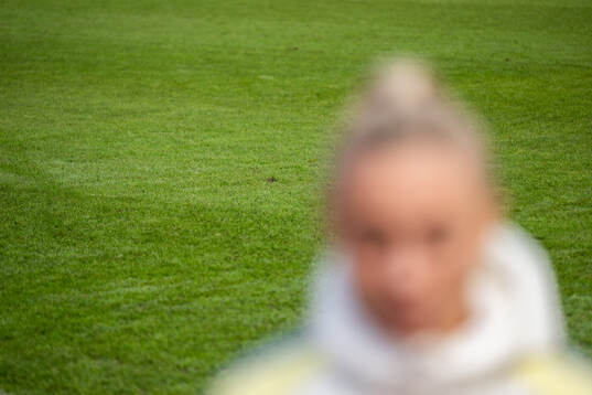 The grass of the pitch is seen behind Fridolina Rolfö of