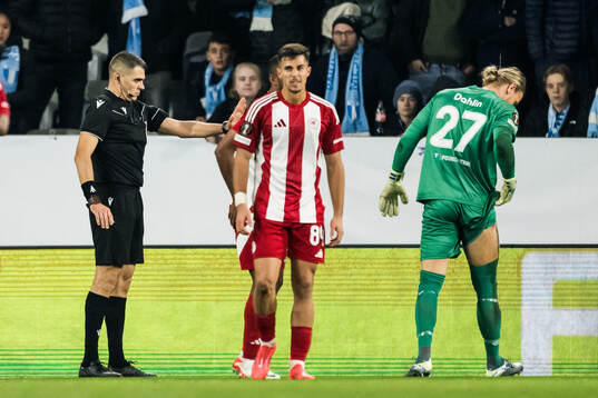 Referee Simone Sozza gives Olympiacos a penalty