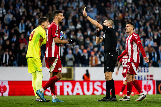 Goalkeeper Kostas Tzolakis of Olympiacos receives a yellow