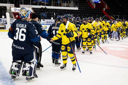 Players from Sweden and of Finland embrace