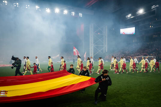 Players of Spain and Denmark enter the pitch