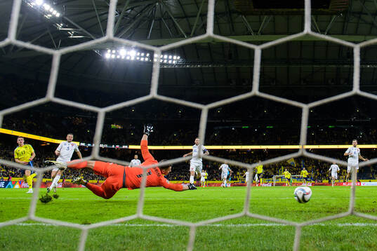 Viktor Gyökeres of Sweden scores 1-0 behind goalkeeper