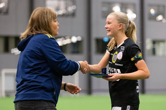 Marie Svensson delar ut en silvermedalj till Uppsalas
