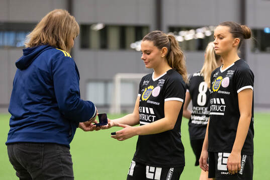 Marie Svensson delar ut en silvermedalj till Uppsalas Lova