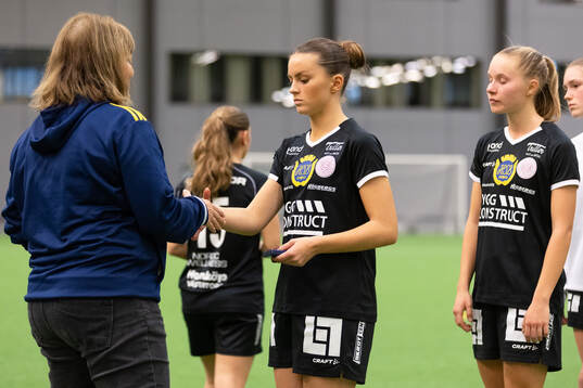 Marie Svensson delar ut en silvermedalj till Uppsalas Stina