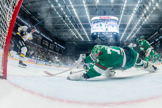 Rögles målvakt Arvid Holm räddar ett skott från HV71s