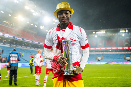Maxwell Woledzi of Fredrikstad celebrates with the trophy