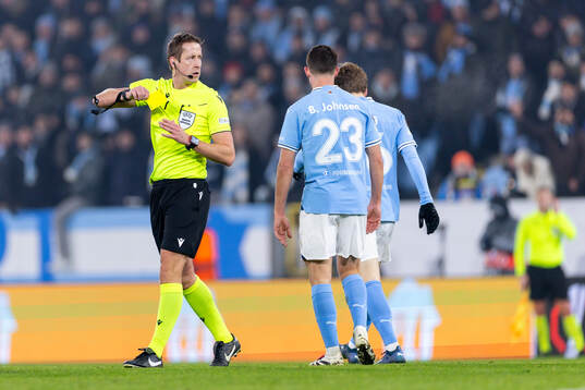 Referee John Brooks with a yellow card