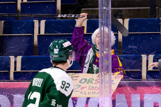 Lucas Forsell of Färjestad  gives his stick to a kid