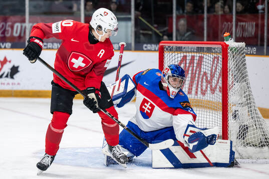 Jan Dorthe of Switzerland and goaltender Samuel Urban of
