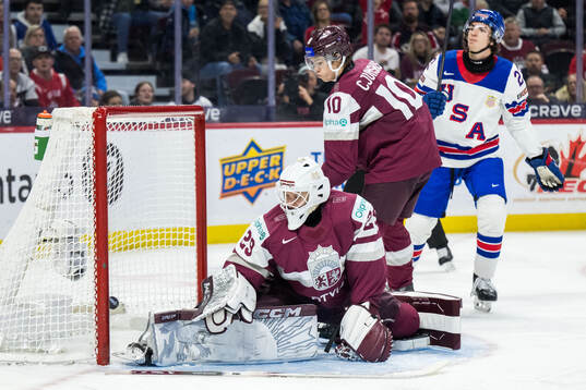 Goalkeeper Linards Feldbergs and Harijs Cjunkis of Latvia