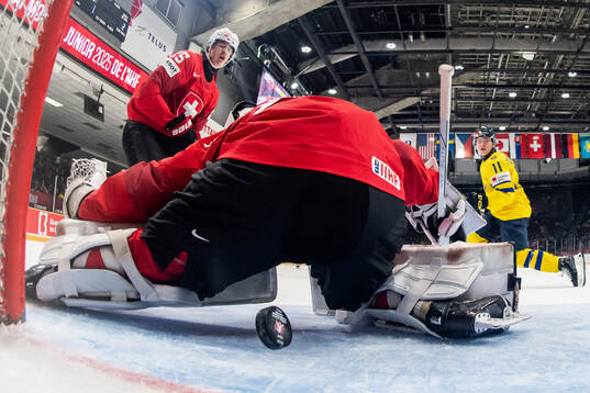 Basile Sansonnens and goaltender Elijah Neuenschwander of
