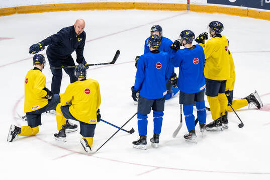 Assistant coach Nicklas Grossmann of Sweden talks to