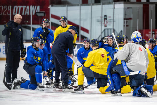 Head coach Magnus Hävelid of Sweden talks to players at a