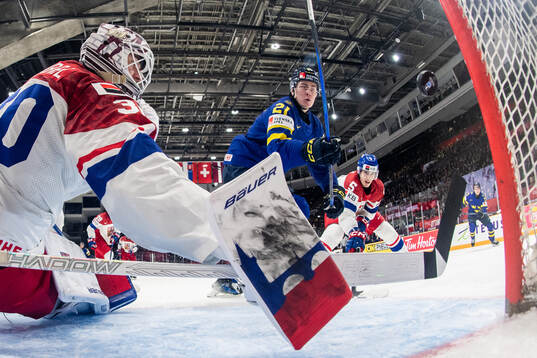 Herman Träff of Sweden scores 2-0 behind goaltender