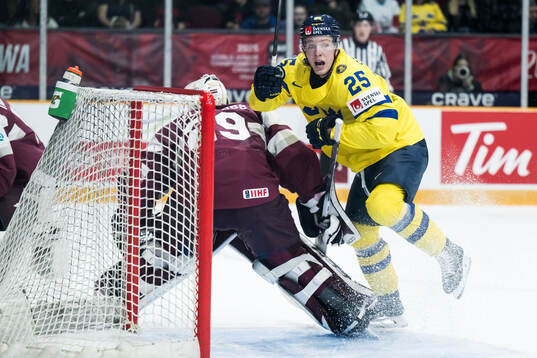 Goaltender Linards Feldbergs of Latvia and Otto Stenberg of