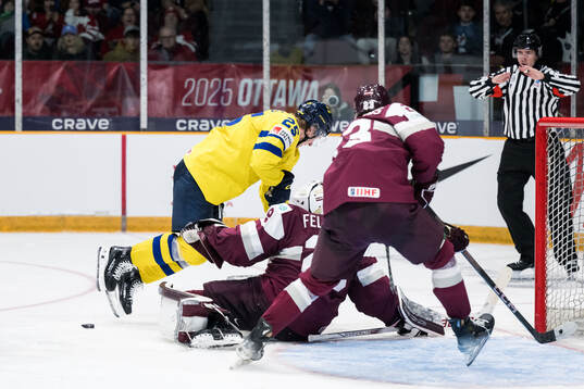Otto Stenberg of Sweden and goaltender Linards Feldbergs of